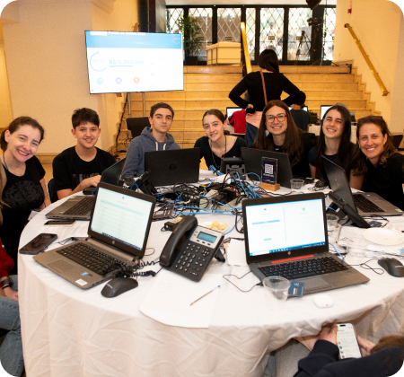 Sete pessoas em volta de uma mesa, sorrindo para a foto.