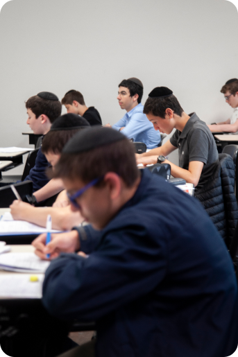 Vários alunos concentrados na tarefa em uma sala de aula.