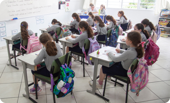 Várias alunas participando de uma aula escolar.